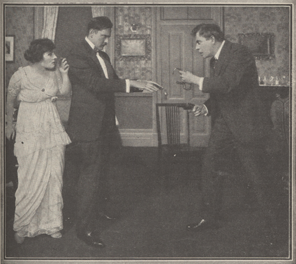 Picture of John Barrymore, as Chick Hewes, holding out his hands to be handcuffed by a police office as actress playing Mrs. Hewes looks on.