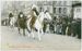 Three Native American men wearing traditional regalia riding on horses