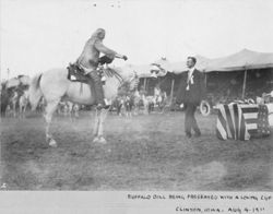 Suited gentleman presents Loving Cup to William F. Cody in show arena