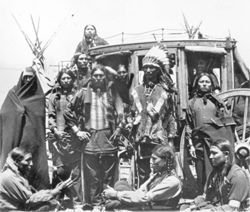 Several Native American men in front of stagecoach