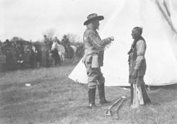 William F. Cody speaking with Native American man beside tipi during filming of "The Indian Wars"