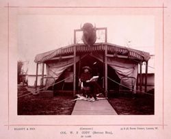 William F. Cody sitting on a chair in front of a tent